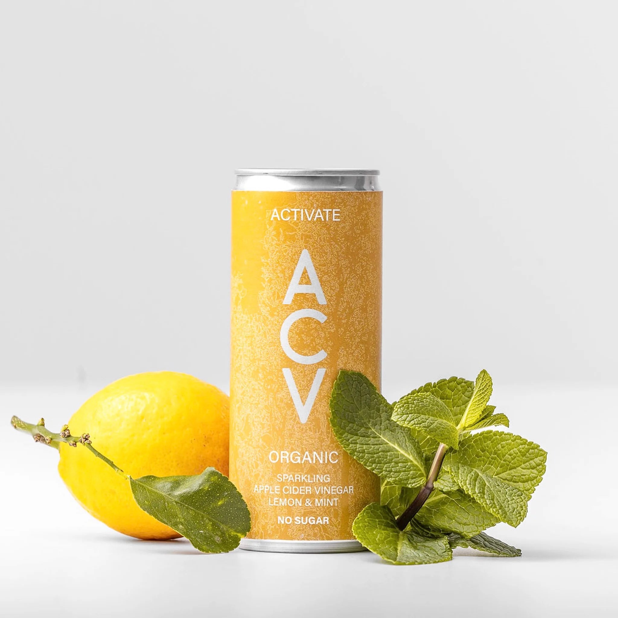 Can of Apealworld ACTIVATE ACV with a lemon and mint leaves on a light grey background